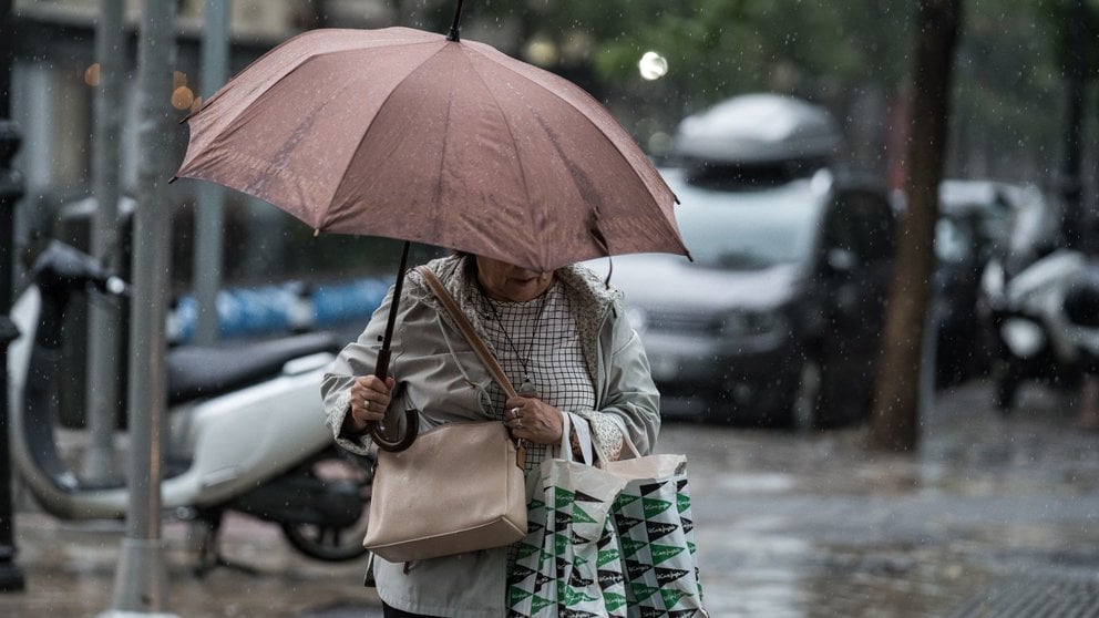 Varias personas se resguardan bajo un paraguas de la lluvia, el viento y el mal tiempo. DIEGO RADAMÉS / EUROPA PRESS